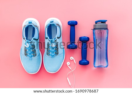 Sport flat-lay with sneakers and water on pink table top view Royalty-Free Stock Photo #1690978687
