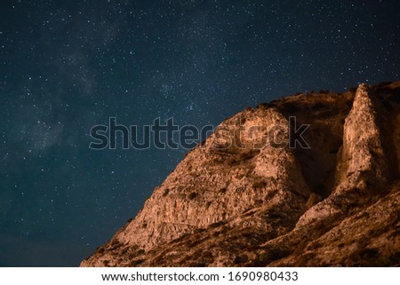 The night sky behind a cliff 