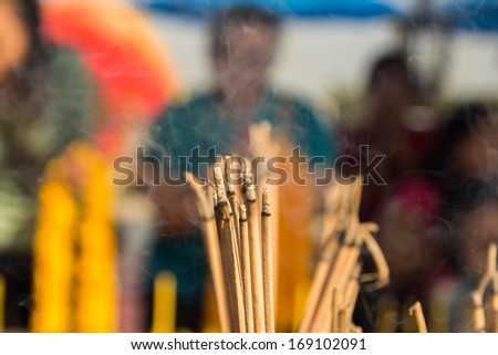 Yellow incense sticks burning in an altar at a Taoist temple