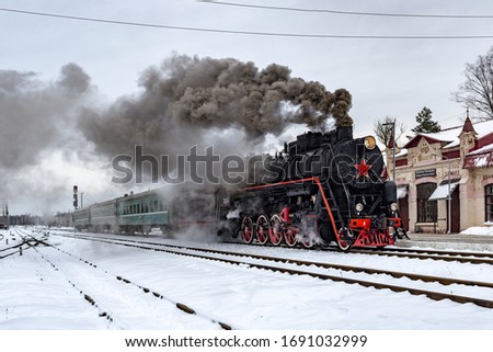 Steam train in winter at the station Bologoe-Polockoe, Tver region, Russia. The inscription on the station building, translation: Bologoe-Polockoe.