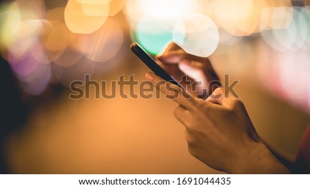 Hands using smartphone on night city Royalty-Free Stock Photo #1691044435