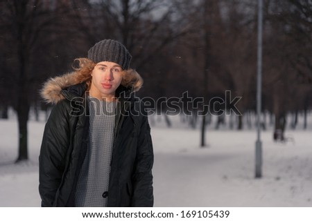 Portrait of young smiling man in the Park at winter