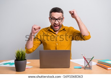 Ecstatic cheerful manager marketer sit desk work home use laptop have online meeting with partners sign contract celebrate lucky success wear yellow shirt isolated gray color background Royalty-Free Stock Photo #1691068363