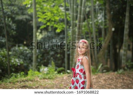 a girl walks through the woods looking around