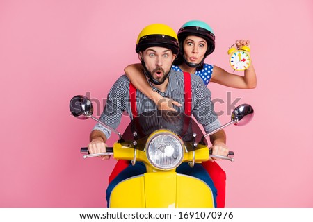 Portrait of his he her she nice attractive worried amazed couple driving moped hurry-up rush holding in hands clock pout lips omg isolated over pink pastel color background Royalty-Free Stock Photo #1691070976
