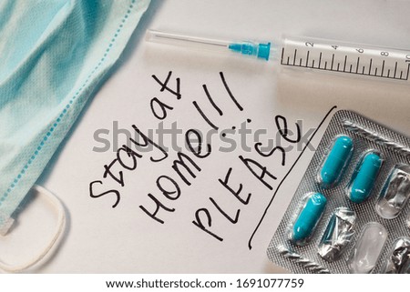 Flat lay. Phrase on white paper with black marker Stay Home. Doctor makes a warning. Stay at home. Coronovirus COVID-19 concept 