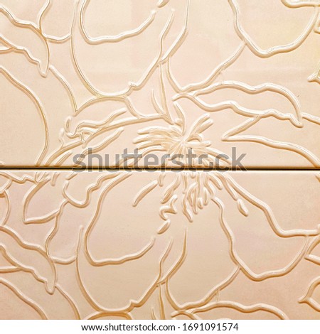 Beige ceramic tiles  with floral pattern for wall and floor decoration. Concrete stone surface background. Texture with flower ornament for interior design project.