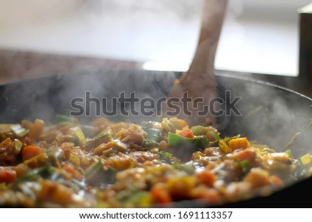 Stir- fry leek, carrot and squash with soy sauce, in a wok. Selective focus.