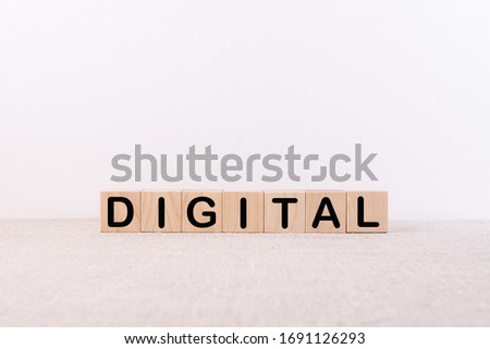 DIGITAL word concept written on wooden cubes blocks lying on a light table and light background