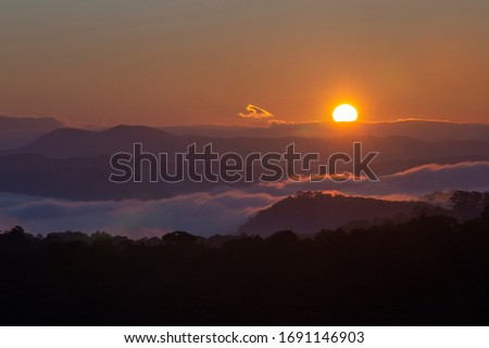 Landscape with Langbiang mountain valley, low clouds, forest, colorful sky. Mountains in fog at beautiful morning  in Dalat city, Vietnam. 