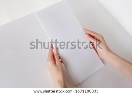 White booklet mockup. Vertical format blank booklet. A woman holds an album with blank pages. Blank cover mocku Royalty-Free Stock Photo #1691180833