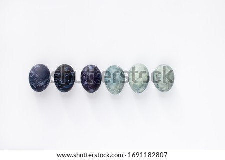 six Easter eggs painted in different shades of blue using natural onion husks