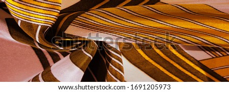 Texture, background, silk fabric with a yellow striped pattern. The design of this fabric is dedicated to a white rabbit mosaic representing the look of a fabulous vest.