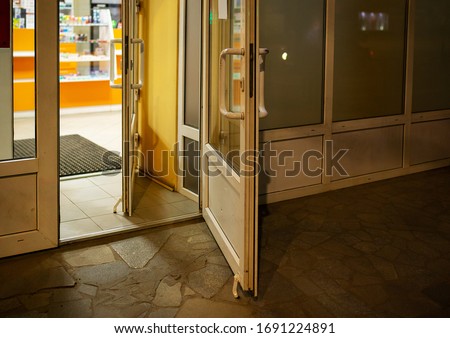 the door to the pharmacy is wide open, the entrance to the store is open so that people do not touch the door handles, restrictive measures during the coronavirus quarantine, care for customers