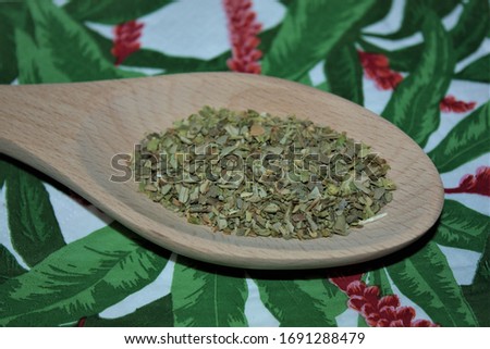 Moscow, Russia-03/2020: Isolated spicy and aromatic thyme (seasoning) in a wooden spoon on a colorful background (kitchen paper napkin). Top view. Closeup.