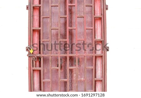 Wooden red door and screen metal door with golden padlock  