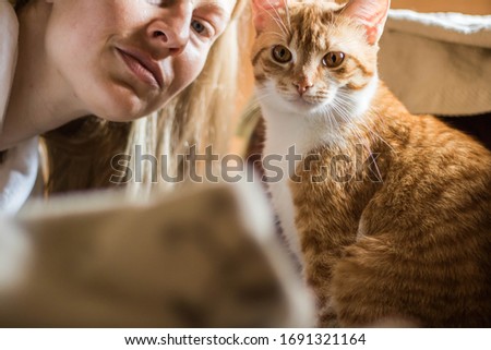 Cute ginger cat and half  face of blonde girl
