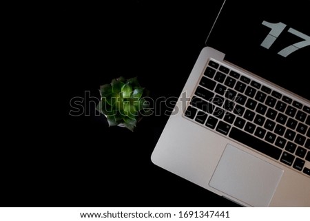 Top view office table concept with laptop coffee cup,  notebook, glasses, succulent on black table background. Mock up notes, copy space