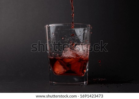 a glass with red water and ice 