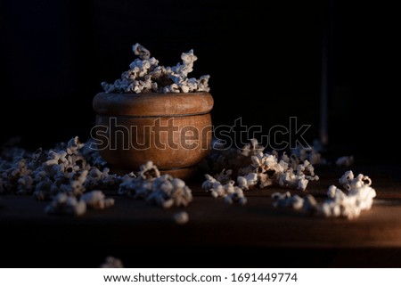 
popcorn in a wooden bowl dark background