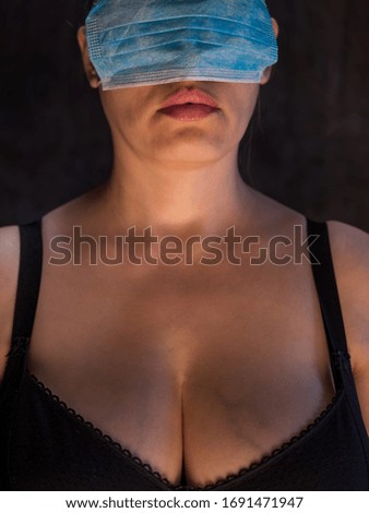 adult girl put on disposable medical mask on her eyes. Beautiful red lips. concept of social problems and lack of personal protective equipment. Coronavirus epidemic Italy, America, China, Spain
