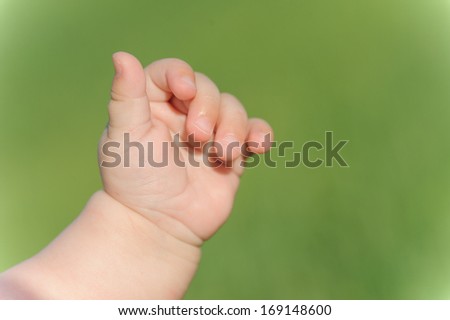closeup of child's hand on green background
