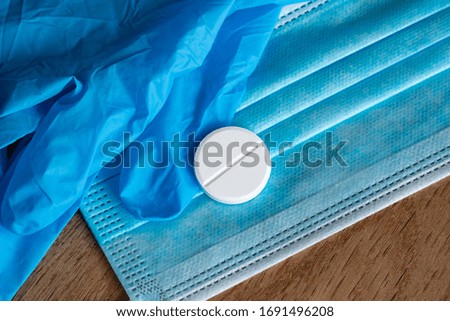 Vaccine COVID-19 Coronavirus. Rubber medical mask, disposable rubber medical gloves, white tablet. Coronavirus tablet. Protective equipment from coronavirus on a wooden background. Close-up image