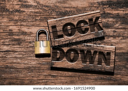 Lockdown sign with padlock on wooden plank. Concept of an emergency protocol that usually prevents people from leaving an area because of something dangerous like the COVID-19 or coronavirus pandemic
