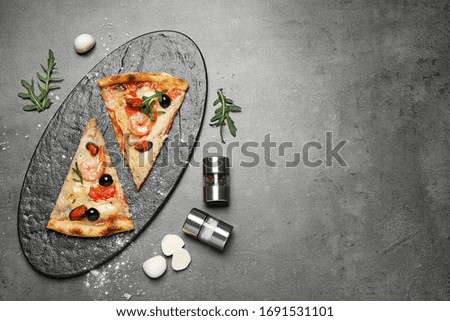 Tasty pizza with seafood and ingredients on grey table, flat lay. Space for text