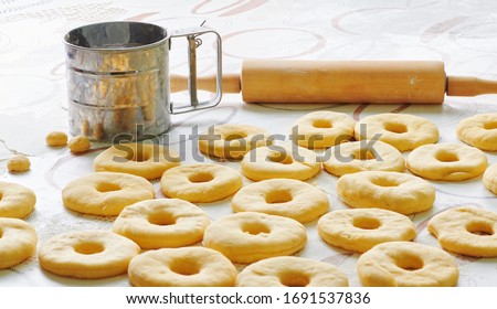 Donut dough is laid out on a table in the kitchen Royalty-Free Stock Photo #1691537836