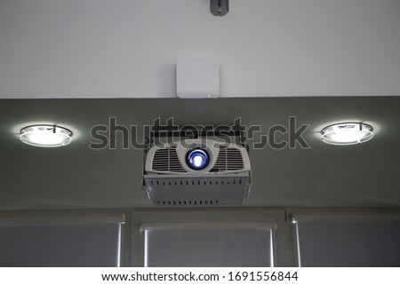 stylish modern projector mounted on the ceiling in the conference room