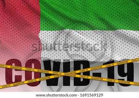 United Arab Emirates flag and Covid-19 inscription with orange quarantine border tape. Coronavirus or 2019-nCov virus concept