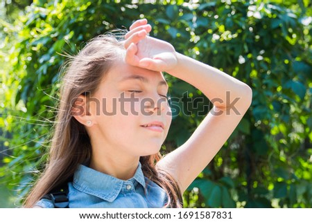 portrait of girl with with closed eyes  posing in park in summer time. summer vacation green background.