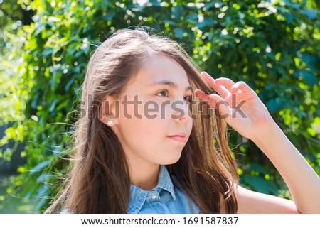 portrait of girl posing in park in summer time. summer vacation green background.