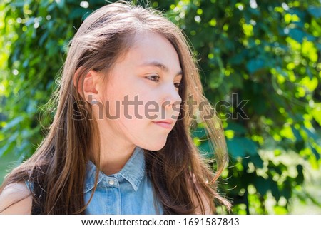 portrait of girl posing in park in summer time. summer vacation green background.