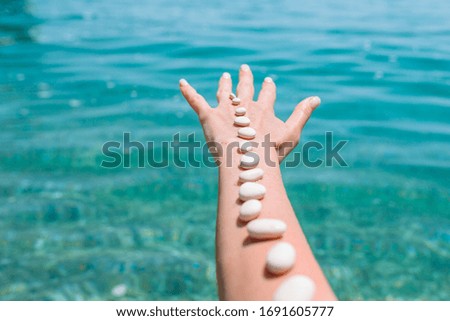 Pebbles on the hand on background. Handful of sea stones. Conceptual design