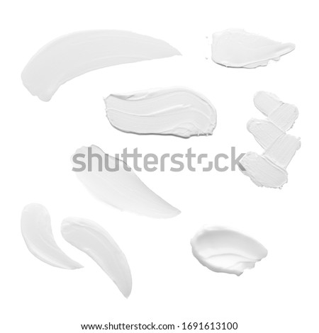 Swabs of creamy textures. Strokes of body lotion or hand cream in different shapes and sizes. Smear of skincare cosmetics product. Cosmetology wellness and beauty concept. Isolated on white Royalty-Free Stock Photo #1691613100