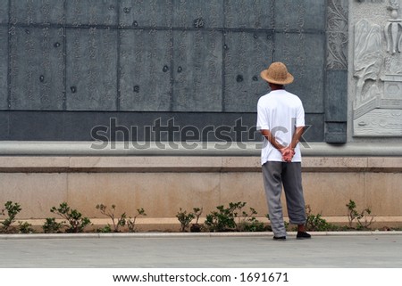 Chinese man reading chinese characters carved on a wall