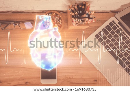 Double exposure of heart drawing over table with phone. Top view. Medical education concept.