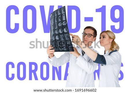 Doctors standing on white background examine x-ray for pneumonia of a Covid-19 patient in the clinic. Coronavirus concept