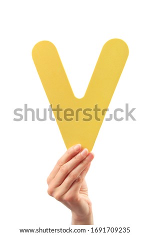 Capital letter V held in woman's hand on white background