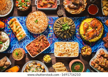Arabic Cuisine: Middle Eastern traditional lunch. It's also Ramadan "Iftar". The meal eaten by Muslims after sunset during Ramadan. Assorted of Arabic oriental dishes. top view with close up.  Royalty-Free Stock Photo #1691716210