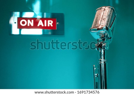 Retro Microphone and on air sign on turquoise wall                                 Royalty-Free Stock Photo #1691734576