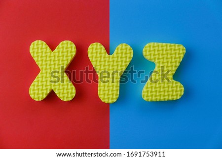 Top view of alphabet XYZ on two color background which are red and blue.