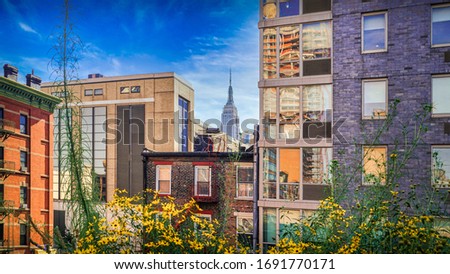 The framed view at the Empire State Building of New York through house facades from the Highline.