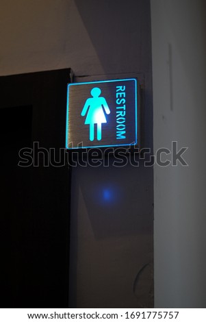 Neon women toilet sign hanging on the wall