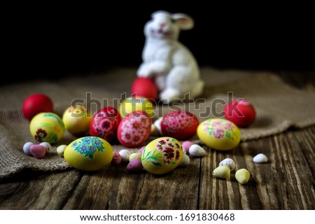 Easter composition on wooden background with rabbit figure. Hand painting Easter eggs. The concept of religious holidays, family traditions. Selective focus. Horizontal orientation. Copy space.