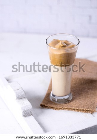 Dalgona Coffee, new variant coffee. Coffee cream mix milk served on glass isolated white background