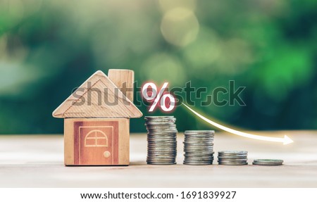 House and coins place on the wood table is ladder with white illustration shows decreasing of interest rates. planning savings money of coins to buy a home concept for property ladder, mortgage. Royalty-Free Stock Photo #1691839927