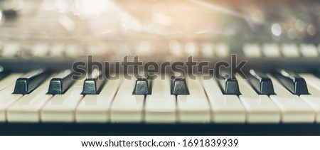 Piano keyboard background was set up in the music room by the windows in the morning to allow the pianist to rehearse before the classical piano performance in celebration of the great success. Royalty-Free Stock Photo #1691839939